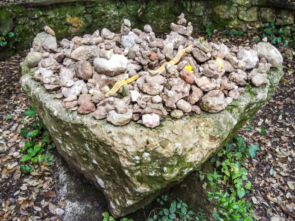 Gelbes Band und Sammlung von kleinen, herbeigetragenen Steinen auf einem großen Bruchstein